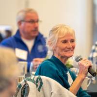 An alumna speaking to the audience.